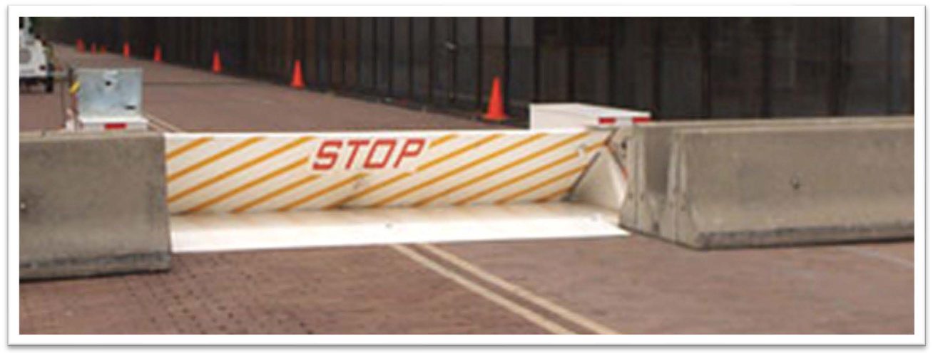 Road Barricade in the Up or STOP position with Jersey Barriers on either side.