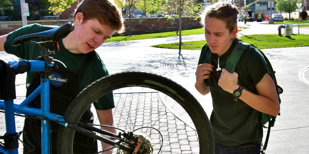 Bike Repair with student showing another student what to do.